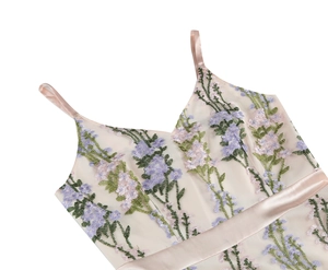 Close-up of V-neck dress with intricate floral embroidery and pink satin straps