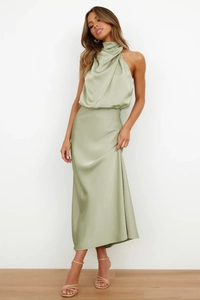 Detail of elegant sage green satin maxi dress showing cowl neck and draped pleats