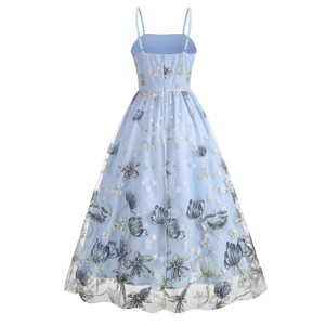 Detailed view of floral embroidery and sheer tulle fabric on light blue midi dress
