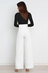 Rear view showing the high waist detail and bow belt of these white wide-leg trousers