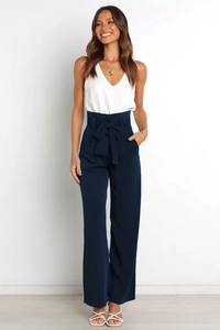 Detail of high-waist navy wide-leg pants featuring a decorative bow tie and loose fit