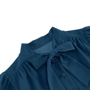Détail de l'encolure de la robe bleu canard avec nœud élégant et boutons recouverts