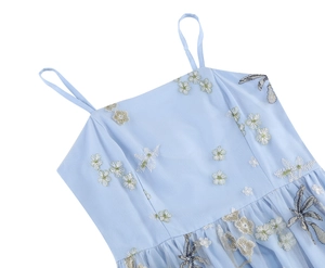Close-up of light blue mesh dress featuring intricate floral and dragonfly embroidery
