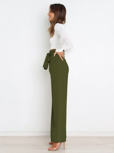 Detail showing high-waisted olive green wide-leg pants with an elegant bow-tie belt design