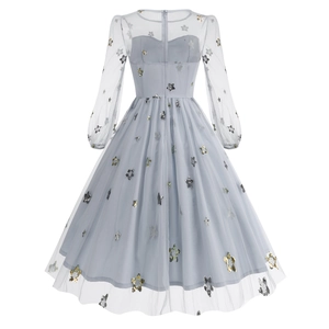 Detail of light blue mesh dress featuring sequin star patterns and a back zipper closure
