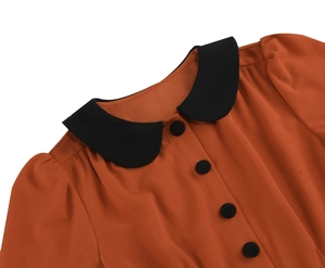 Detailed close-up of orange vintage dress with black Peter Pan collar and buttons