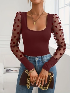 Detail of burgundy U-neck knit top with sheer mesh sleeves and velvet polka dots