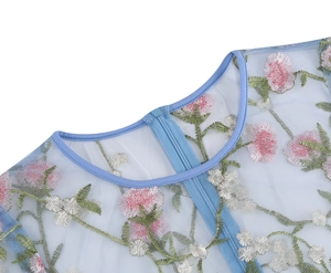 Detail of floral embroidery on light blue mesh fabric with front zipper and round neckline
