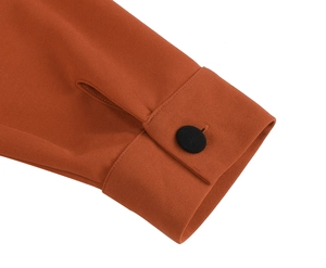 Detail of caramel vintage dress sleeve with black button and precise stitching