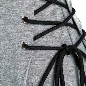 Detail von grau meliertem Stoff mit schwarzen Kordeln und silbernen Metallösen
