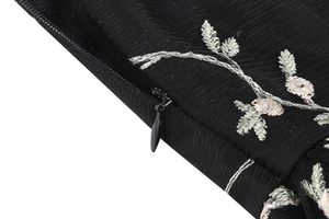 Detailed close-up of embroidery and invisible zipper on black vintage tulle dress