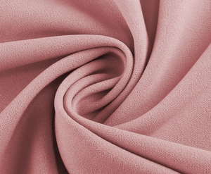 Close-up of elegant dusty pink chiffon fabric with fine grainy texture and soft drape
