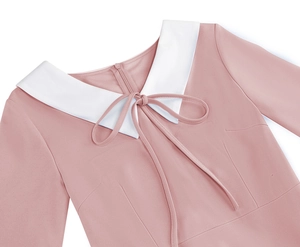 Detail of elegant contrast Peter Pan collar with delicate bow on a dusty pink midi dress