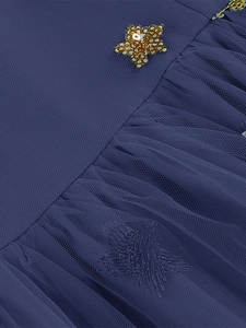 Macro shot of dark blue mesh dress with gold sequined stars and delicate pleated texture