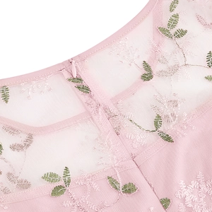 Détail d'une robe en tulle rose avec broderie florale et fermeture éclair invisible