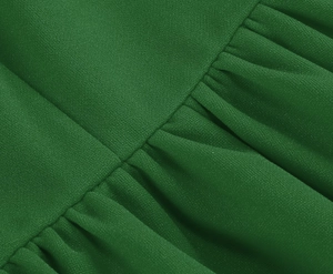 Macro shot of emerald green chiffon fabric showing subtle texture and pleated ruffled details