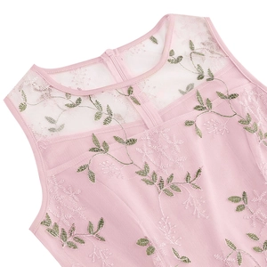 Détail d'une robe en tulle rose à col rond avec broderie florale et fermeture éclair discrète