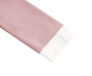 Detailed view of pink textile dress sleeve with white contrast cuff and textured fabric