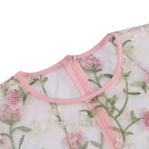 Detail of floral embroidery on breathable mesh fabric with a pink concealed zipper