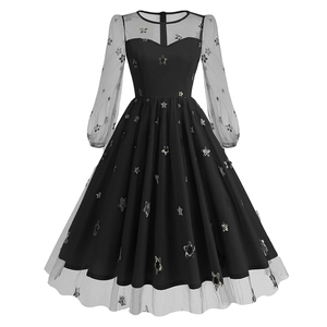 Close-up of black A-line dress with sheer mesh puff sleeves and sparkling star sequins
