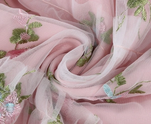 Close-up of pink mesh fabric with detailed floral embroidery on a vintage party dress