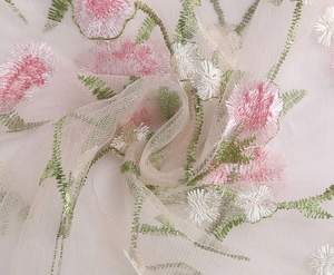 Close-up of vintage floral embroidery on mesh fabric for a delicate French style dress