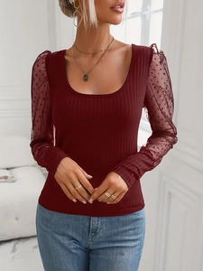 Dettaglio delle maniche a sbuffo in mesh bordeaux con pois su top in maglia