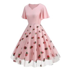 Close-up of pink 1950s cocktail dress featuring mesh overlay with strawberry embroidery