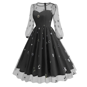 Detail of black evening dress featuring sheer mesh sleeves and silver sequin star patterns