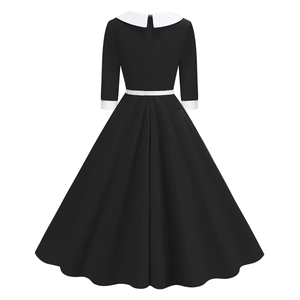 Detail of elegant black dress with contrast white collar and delicate white waist belt