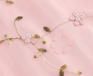 Gros plan sur tissu tulle rose avec broderie florale 3D et détails de feuilles dorées