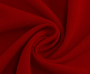 Close-up of deep red vintage dress fabric texture with soft drapes and elegant weave