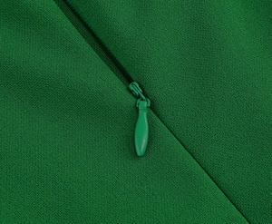 Macro shot of green woven fabric with a matching invisible teardrop zipper detail