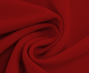 Close-up of deep red vintage dress fabric with high-quality crepe texture and elegant grain