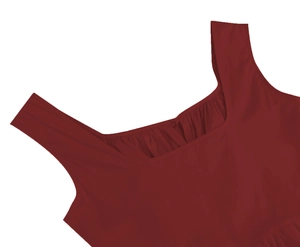 Détail de l'encolure froncée et du tissu rouge foncé lisse sur une robe sans manches