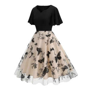 Detail of vintage 50s cocktail dress with butterfly embroidery on beige mesh skirt