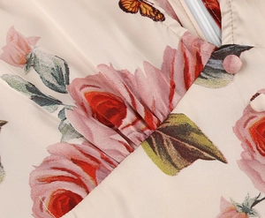Detail view of V-neckline with zipper and delicate floral butterfly prints on dress