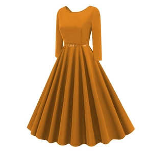 Detailed view of the pleated skirt and waist belt of a vintage orange midi dress