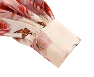 Detail of satin floral dress sleeve showing retro rose pattern and pleated cuff design