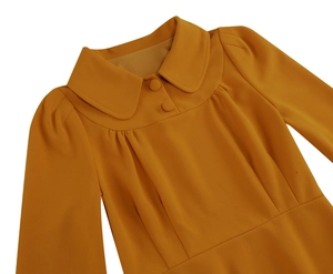 Detail view of the yellow Peter Pan collar and textured woven fabric with fabric buttons