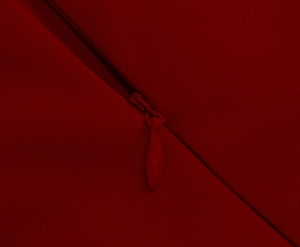 Macro shot of invisible back zipper on the dark red elegant midi dress fabric