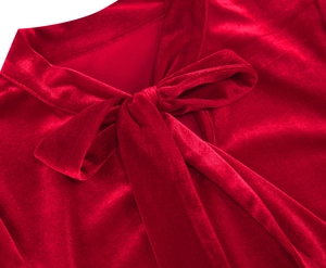 Detailed close-up of a red velvet dress showing the elegant bow tie neck and soft fabric texture