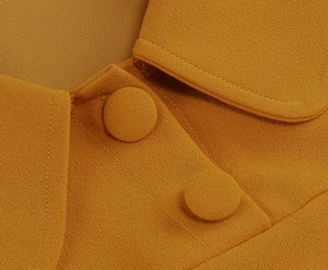 Detail of ginger yellow dress featuring fabric texture and elegant matching buttons