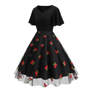 Detailed view of red cherry embroidery on black mesh cocktail dress with butterfly sleeves