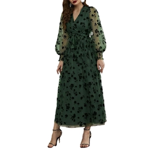 Détail d'une robe vert foncé avec broderie florale et manches lanterne transparentes