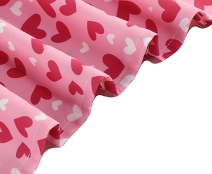 Détail du motif imprimé cœur sur tissu plissé rose avec couture fine