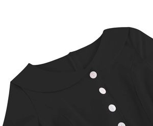 Detail of elegant black dress featuring a wide white Peter Pan collar and glossy buttons