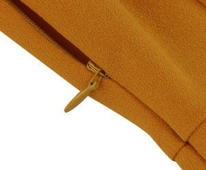 Detail shot of a mustard yellow dress showing invisible zipper and textured fabric