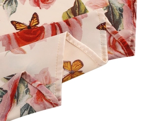 Detail of floral print chiffon fabric with pink roses and butterflies on apricot base