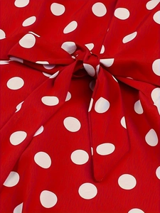 Close-up of the vintage red polka dot dress featuring a decorative bow tie detail